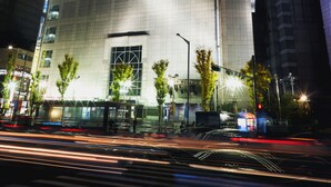 Un hotel con un llamativo letrero 'Migliore', arquitectura moderna y una fachada bien iluminada.