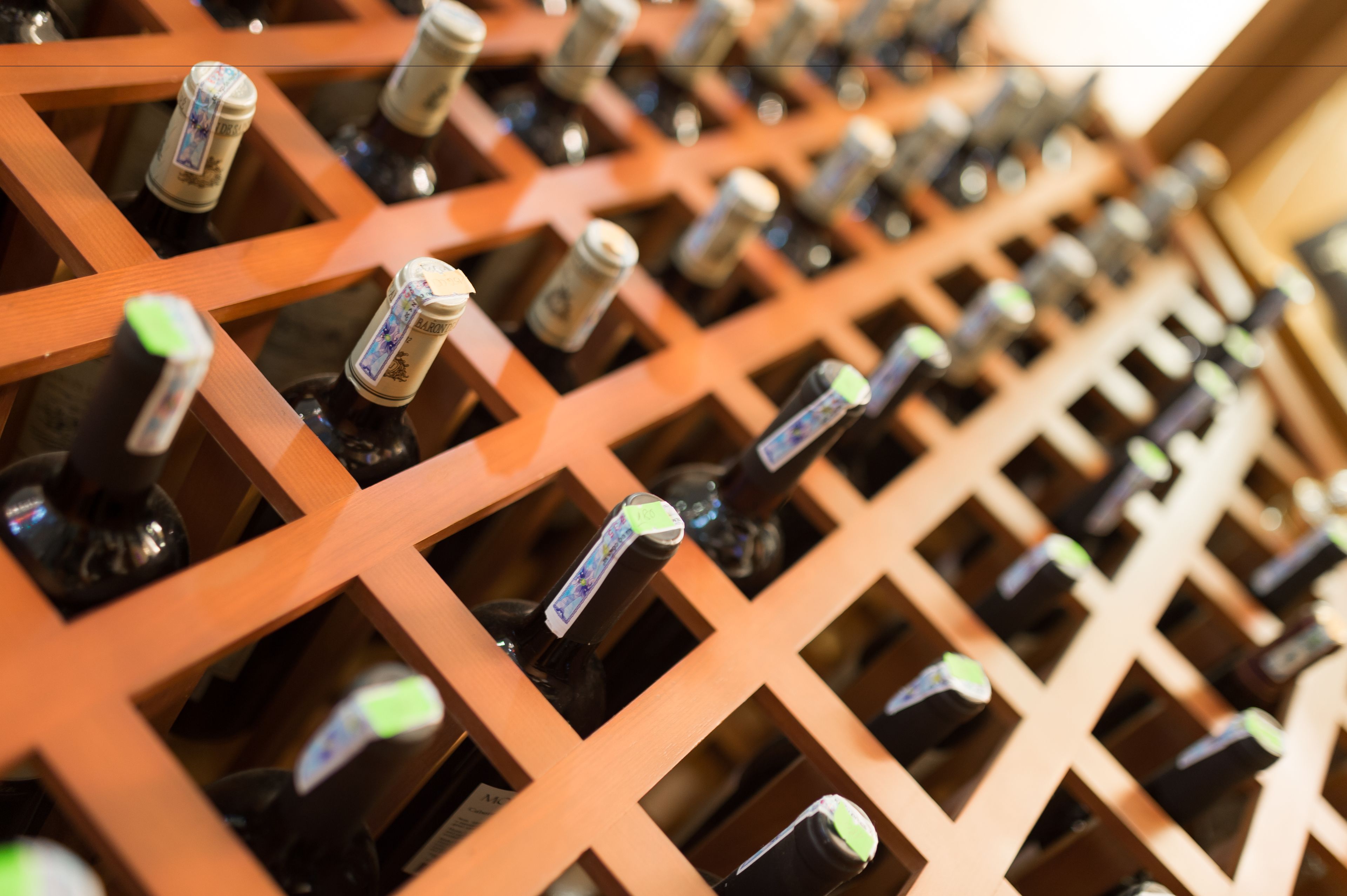Ein Weinschränkchen mit mehreren Flaschen, die gitterförmig angeordnet sind.