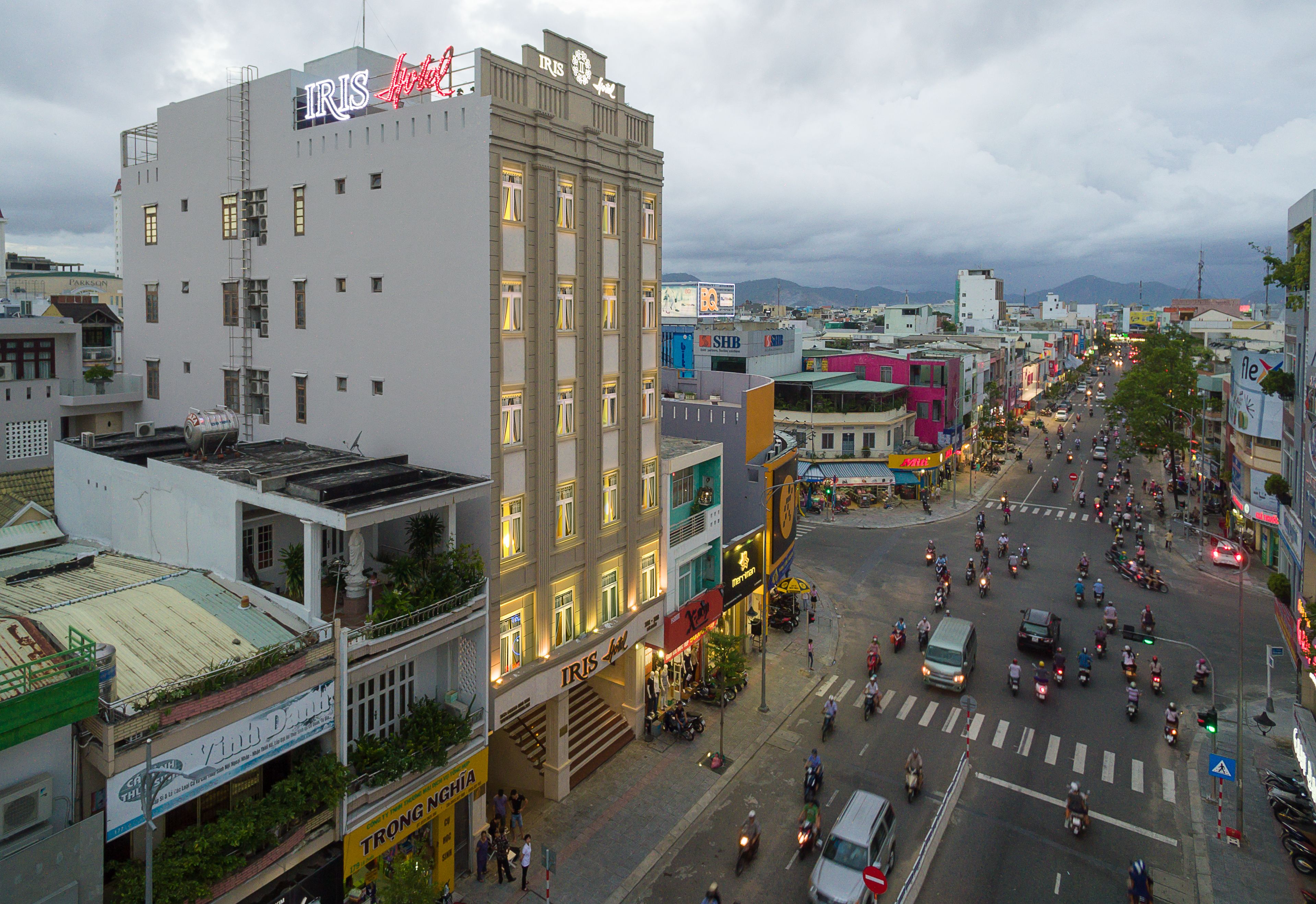 A multi-story building with a prominent sign for 'IRIS Hotel'.