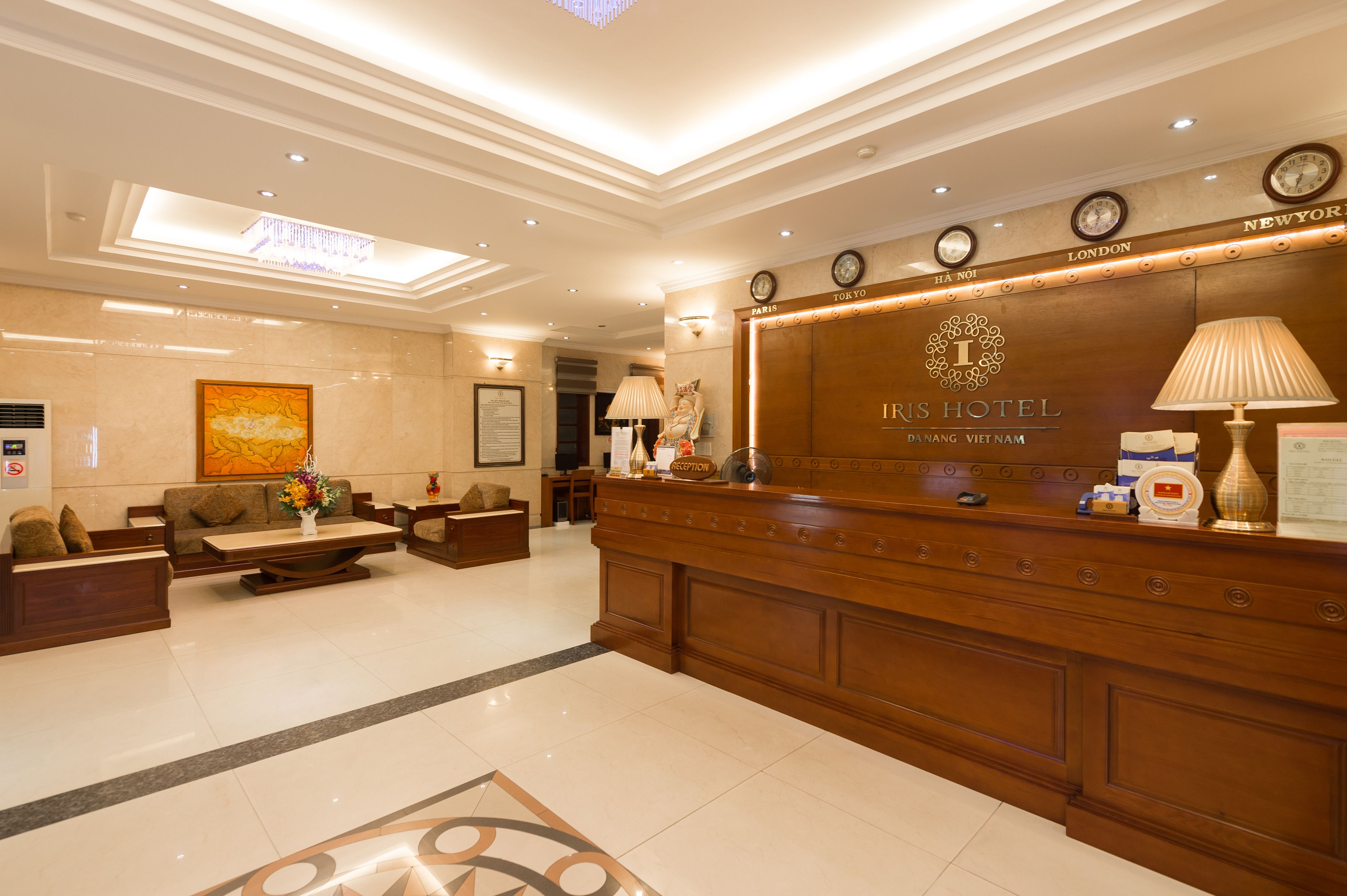 A hotel reception area with a wooden reception desk, a sofa, and a coffee table.