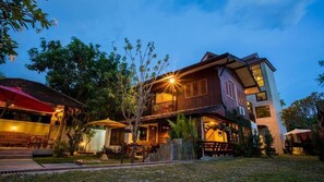 Vista frontal de la propiedad por la tarde o noche