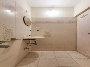 A bathroom with a sink, mirror, and shower area. - OYO 1074 Apartment Banjara Hills (Hyderabad)