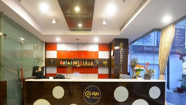 A hotel reception desk with a modern design, featuring a logo and a counter. - OYO Rooms Banjara Hills Road No 1 (Hyderabad)