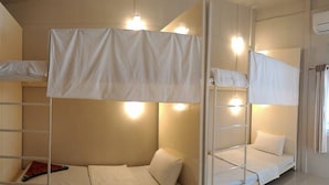 A bunk bed room with white bedding and overhead lighting. - The Best Hostel (Koh Tao)