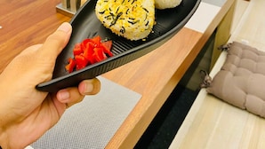 A tray with sushi and a side of pickled vegetables in a hotel setting. - YUHI MANSIONS | A Boutique Stay (Gurugram)