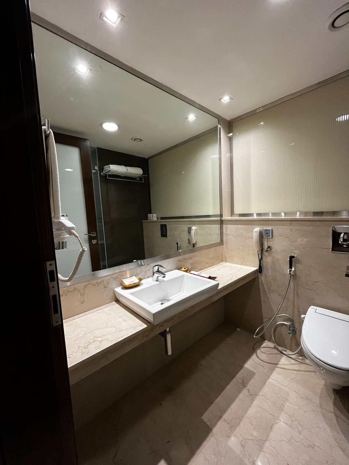 Ein modernes Badezimmer mit großem Spiegel, zwei Waschbecken, Toilette und Dusche.