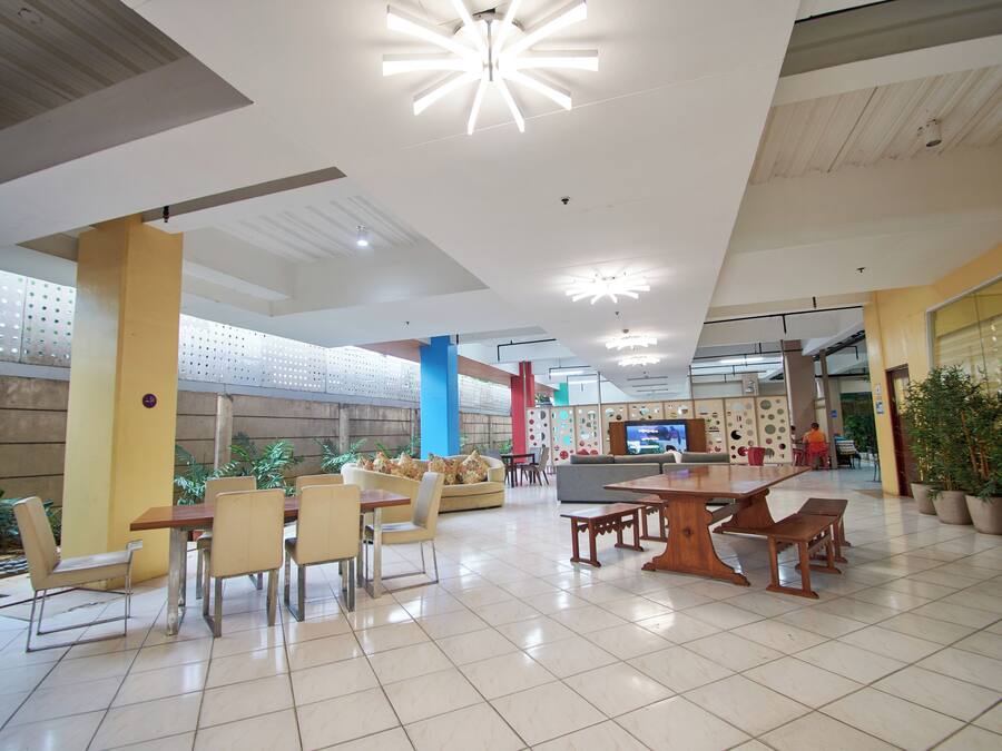 Un espacio interior amplio con mesa de comedor, sillas, sofás y televisor.