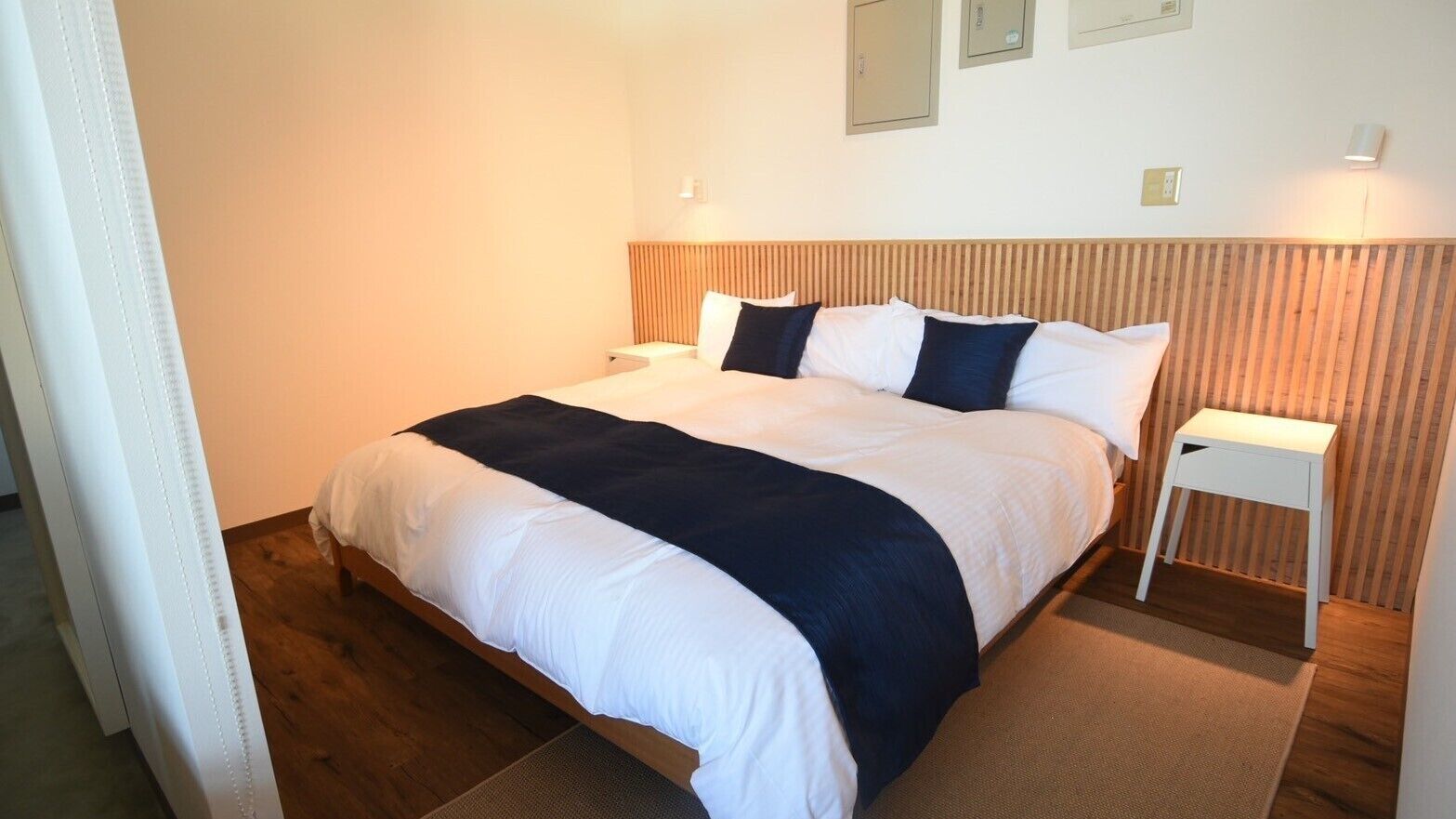 Ein Hotelzimmer mit Bett, Nachttisch und einer Wandleuchte.