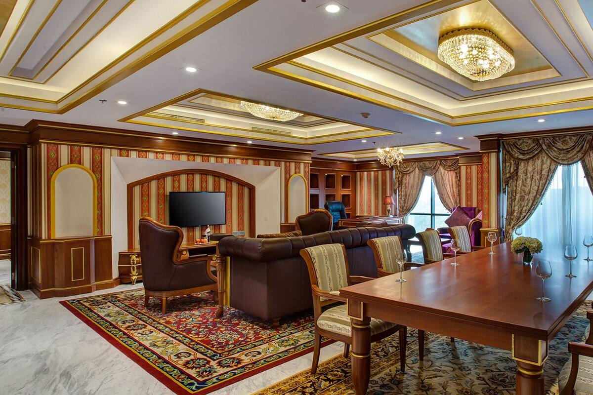 A spacious room with a large wooden dining table, comfortable seating, and a television.