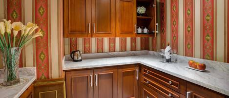 Una cocina con armarios de madera, encimera de mármol y un jarrón con flores.