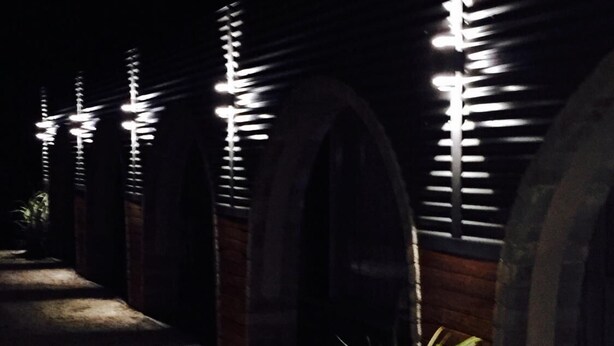 A dimly lit corridor with arched ceilings and a potted plant in the foreground. - Thomas Lodge Motel (Tocumwal)