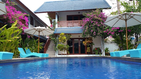 Una piscina al aire libre, tumbonas