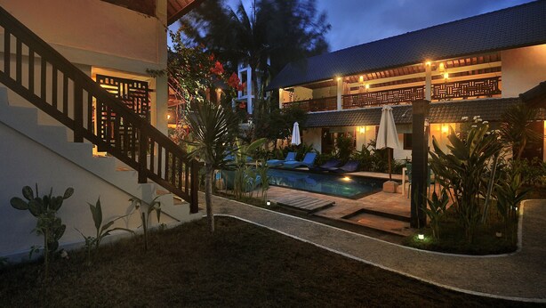A two-story building with a swimming pool, outdoor seating, and a staircase. - Marygio Resort (Gili Trawangan)