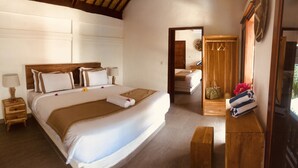 A well-lit bedroom with a large bed, wooden headboard, bedside tables, and a wooden wardrobe with a mirror. - Marygio Resort (Gili Trawangan)