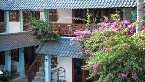 A traditional building with a tiled roof, wooden balconies, and a staircase leading to the entrance. - Marygio Resort (Gili Trawangan)