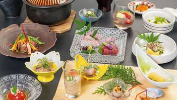 A variety of dishes and drinks on a table, including a pot, bowls, and glasses.