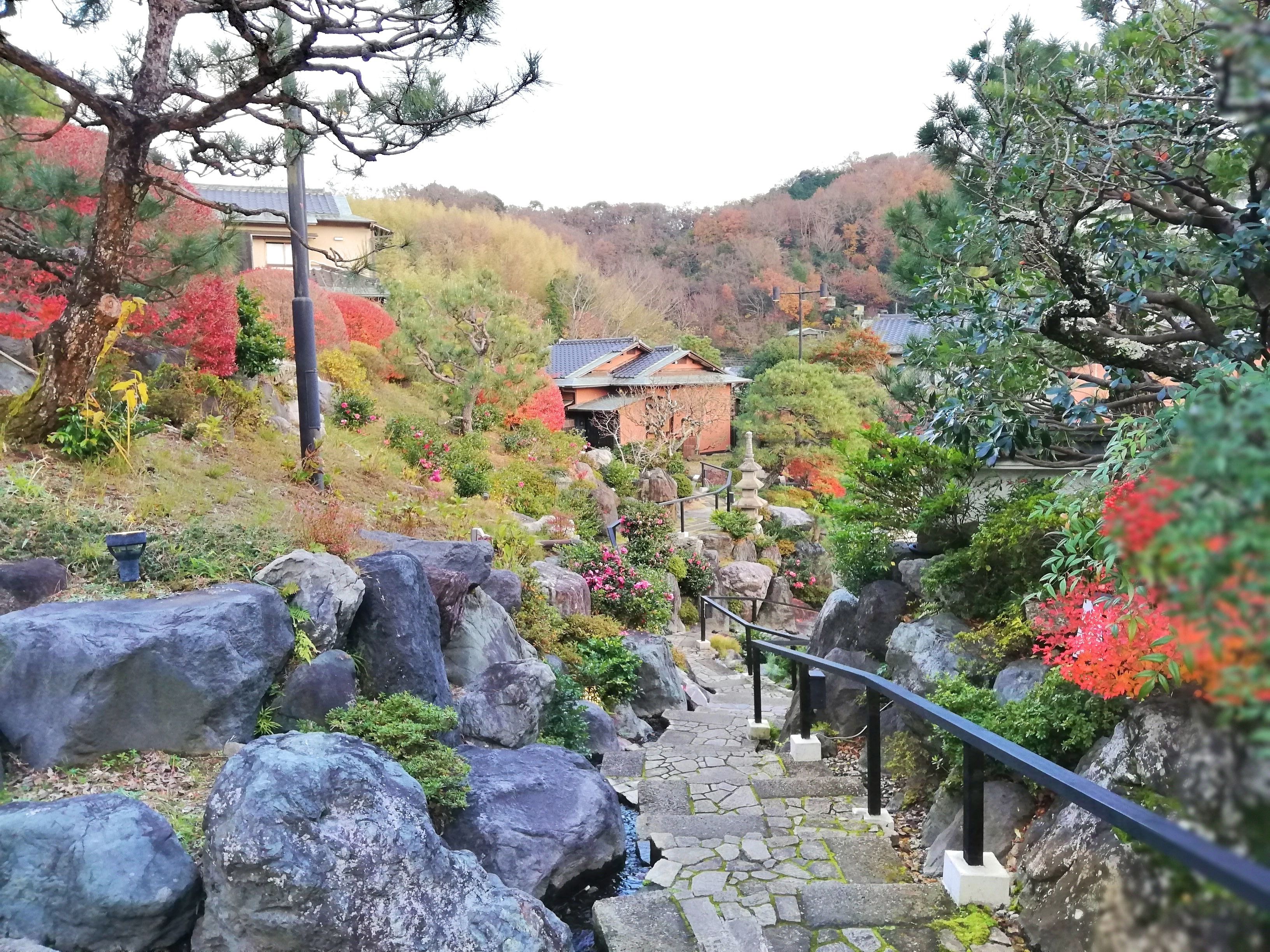 A stone staircase leading up a hill with a traditional building in the background.