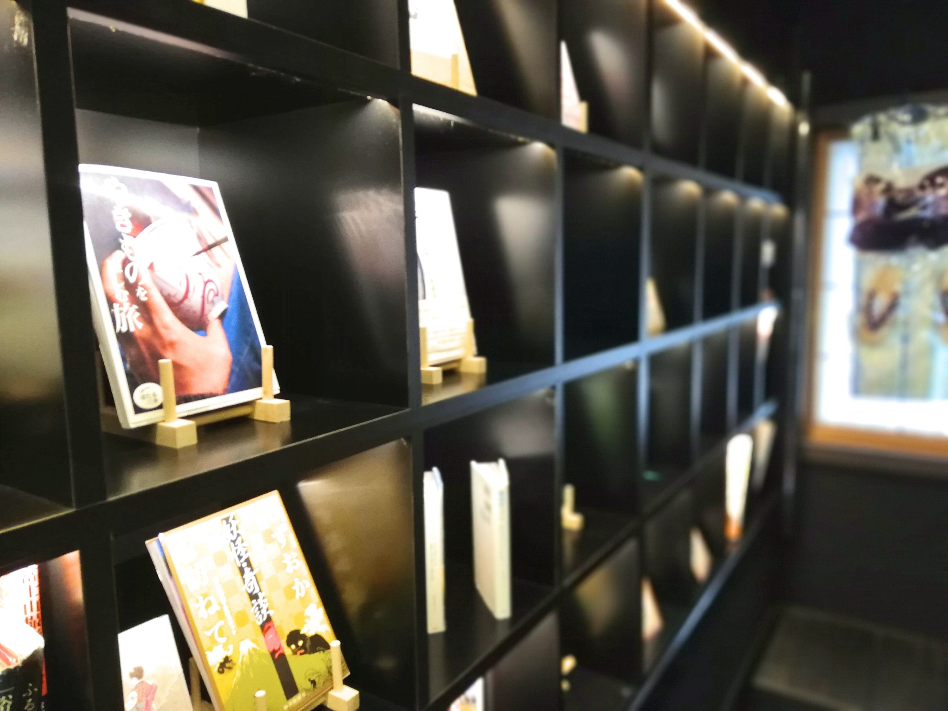 A wall with multiple framed items, possibly artwork or photographs, displayed on shelves.
