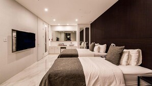 A modern hotel room with a large bed, a TV, a bathroom with a mirror, and a dark accent wall. - Hotel the May (Namyangju)