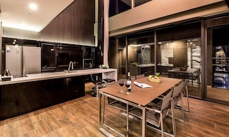 Una cocina moderna con comedor, que incluye una isla grande, electrodomésticos de acero inoxidable y vistas de la ciudad de noche.