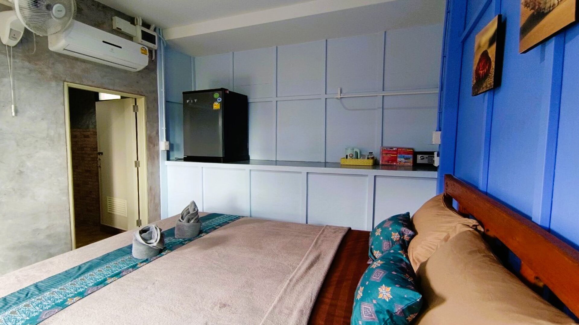 A bedroom with a bed, a TV, and an air conditioning unit.