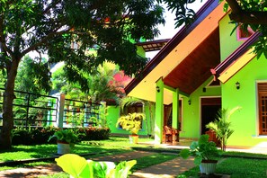 A green house with a porch, a potted plant, and a pathway. - Nature Resort Tissamaharama (Thissamaharama)