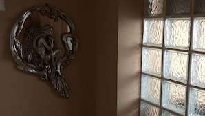 A wall with a decorative metal piece and a window with textured glass panels. - Rose Rooms Apart (Istanbul)