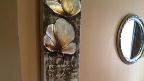 A bedroom with a bed, a bedside table with a vase of flowers, and a wall-mounted artwork. - Rose Rooms Apart (Istanbul)