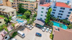 Un hôtel comprenant plusieurs bâtiments, une piscine et un parking.