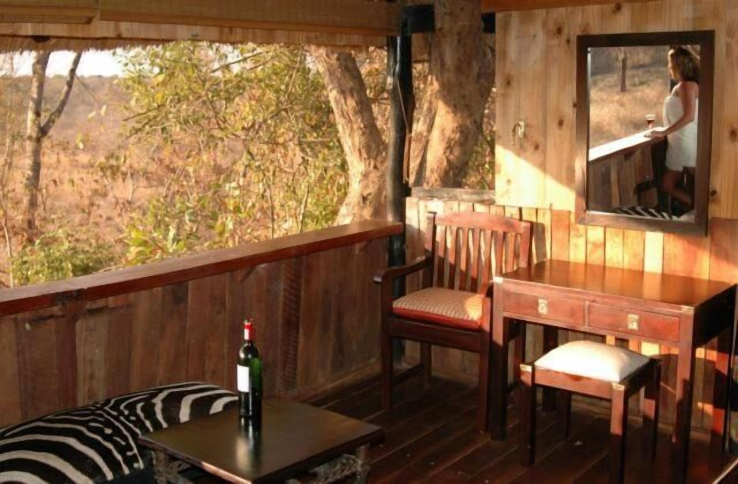 Una terraza de madera con una mesa, una silla y un banco.