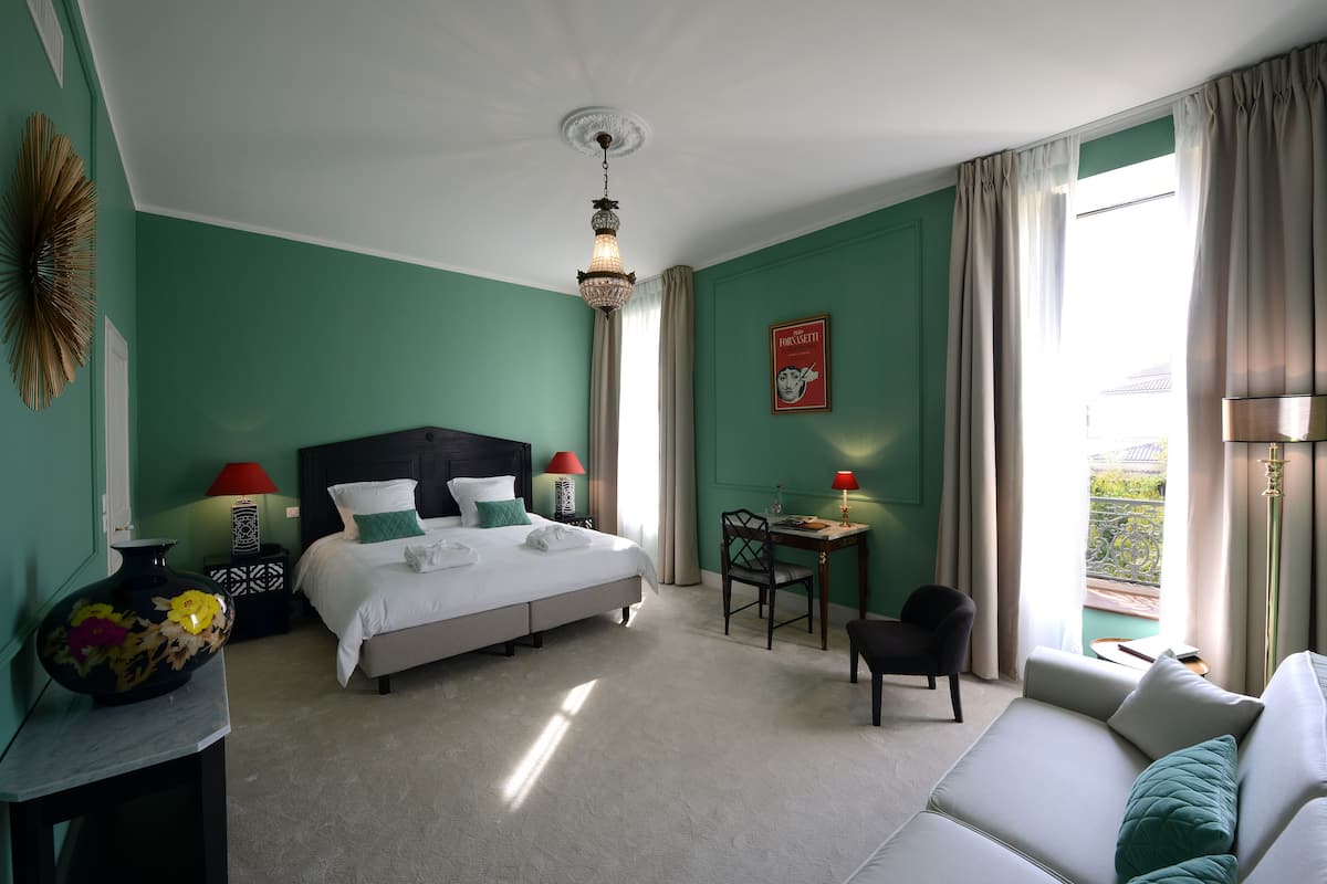 Une chambre d’hôtel avec un lit, un bureau, une chaise et un canapé.
