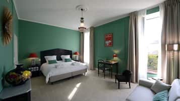 A hotel room with a bed, a desk, a chair, and a sofa.