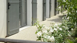 Une rangée de portes grises portant les numéros 15 et 16, indiquant des chambres d’hôtel.