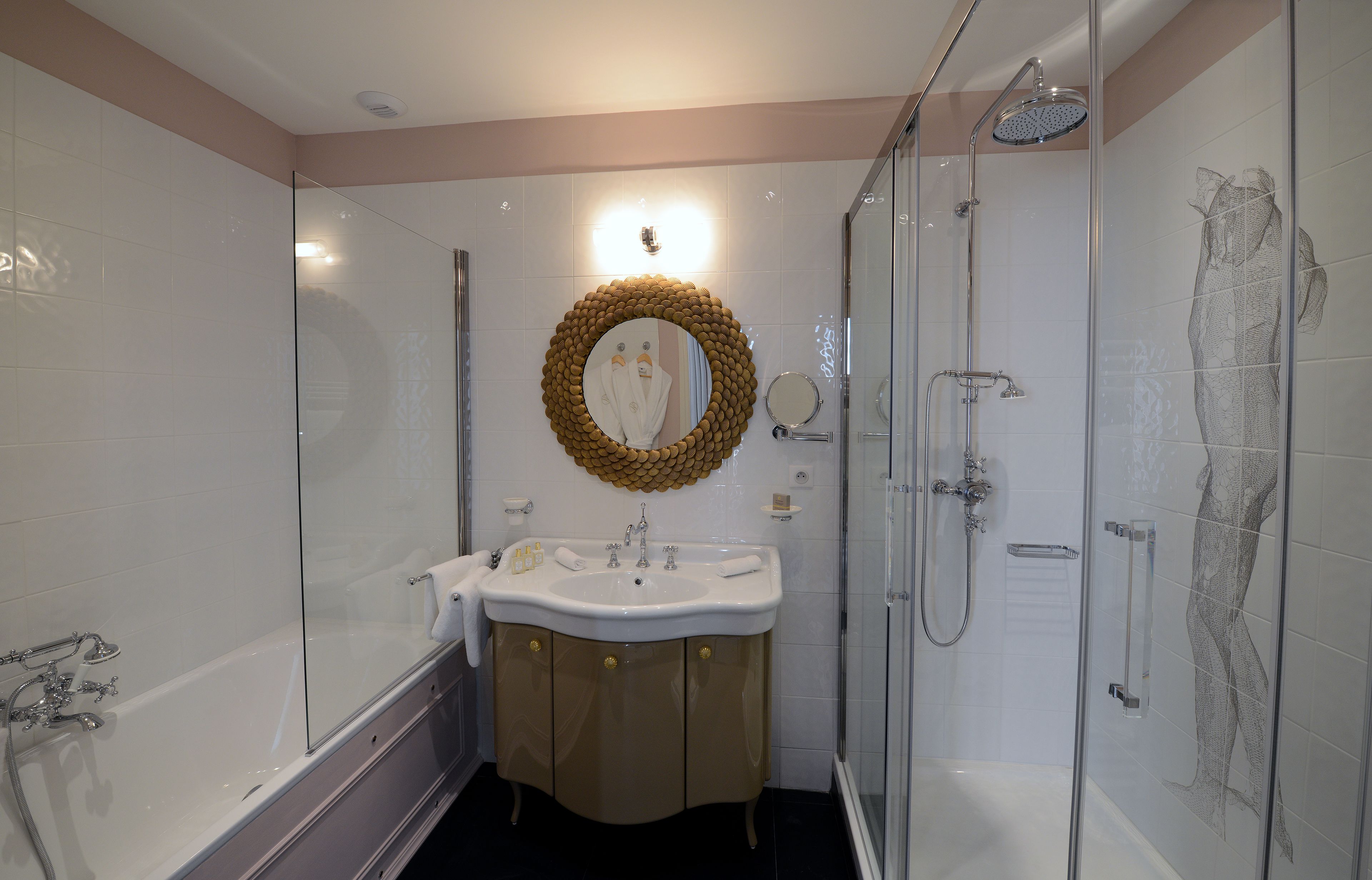 Un baño moderno con bañera, lavamanos con tocador, ducha y cabina de ducha con mampara de vidrio.