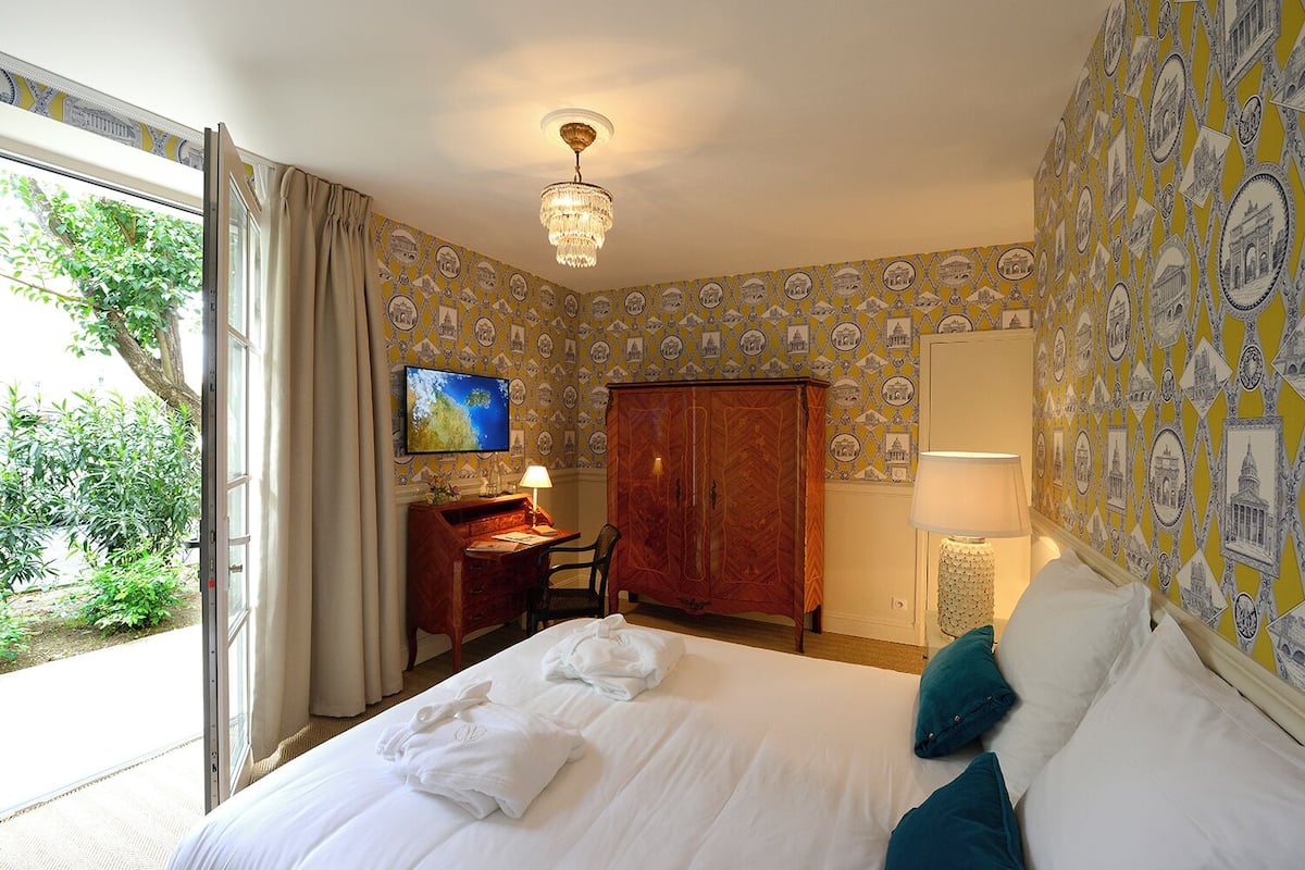 Une chambre d’hôtel équipée d’un lit, d’un bureau, d’une télévision et d’une armoire.