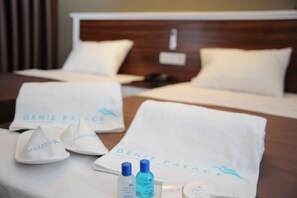 A hotel room with a bed, two towels, and toiletries. - Deniz Palace Hotel (Istanbul)