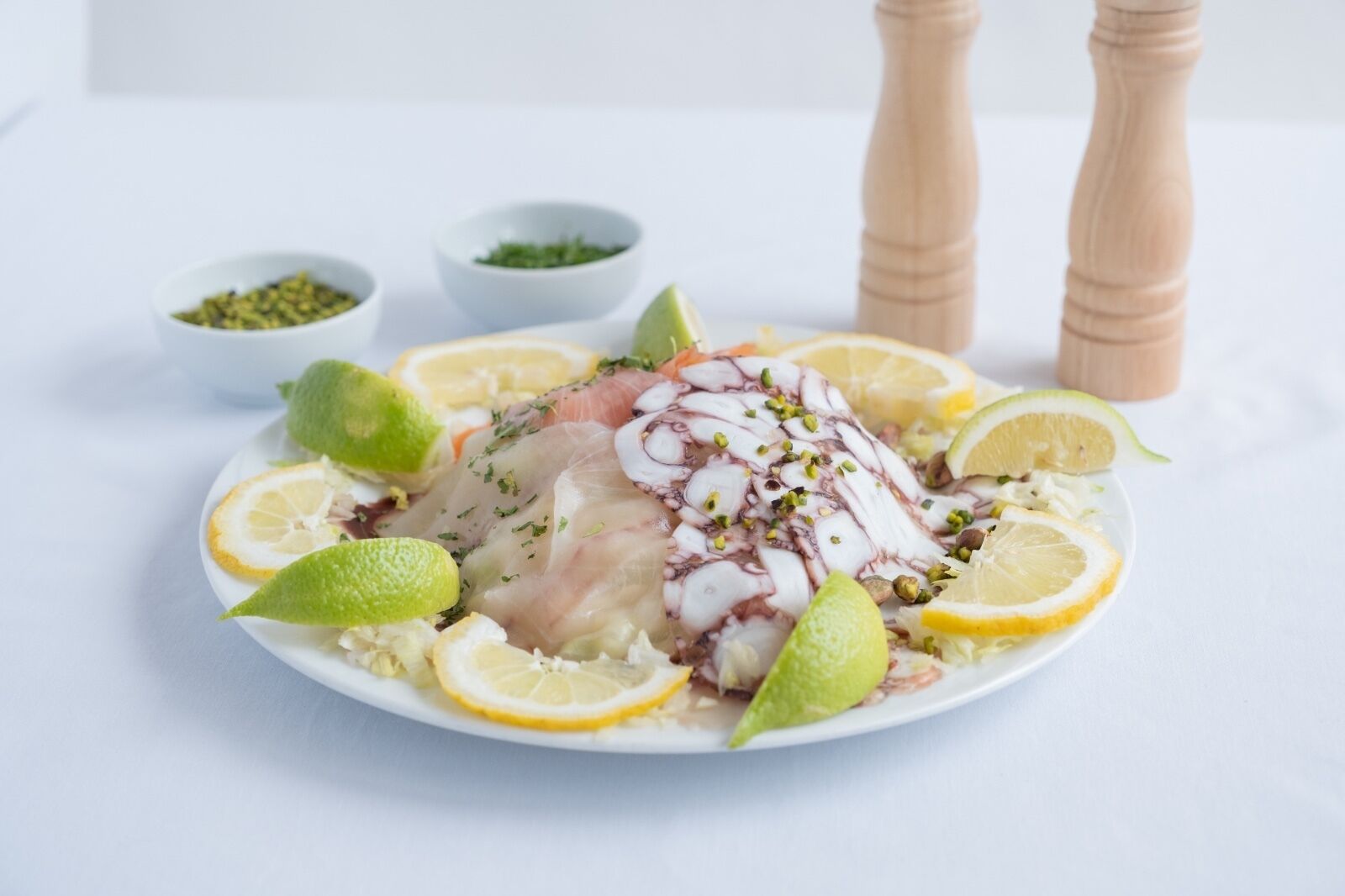 Ensalada de pulpo con rodajas de limón y hierbas.