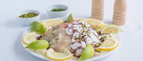 Ensalada de pulpo con rodajas de limón y hierbas.