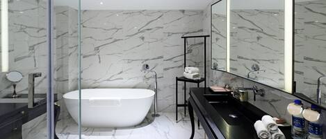 A modern bathroom with a freestanding bathtub, a glass-enclosed shower, and a black vanity with a large mirror.