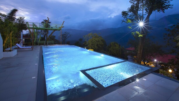 Une piscine avec vue sur les montagnes au crépuscule.