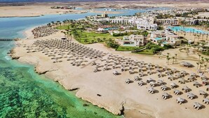 Ein Resort mit Strand, Pool und mehreren Gebäuden.