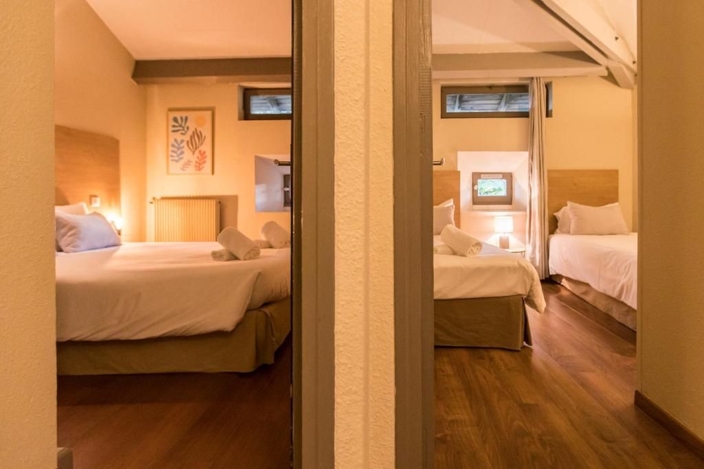 Ein Hotelzimmer mit zwei Betten, einem Spiegel und einer Heizung.