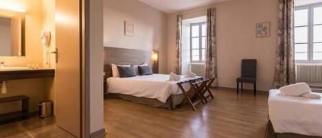 Una habitación de hotel con cama, escritorio, silla y zona de baño.