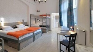 A bedroom with bunk beds, a desk, and a chair. - Hostel Lwowska 11 (Warsaw)