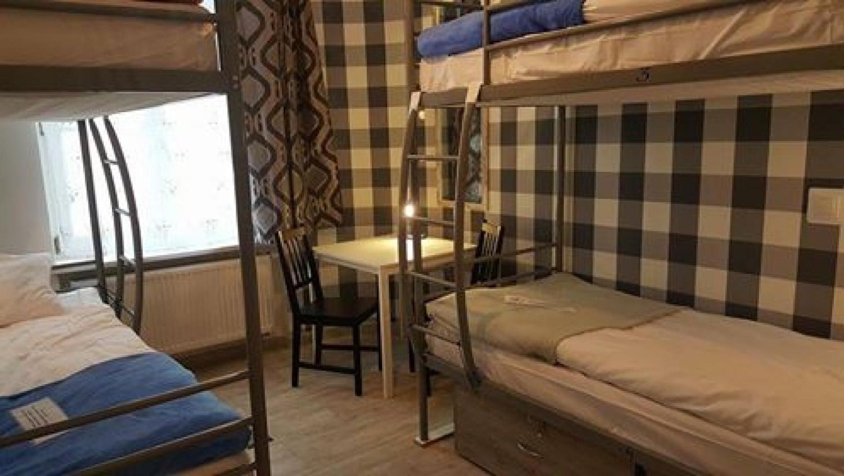 Un dormitorio con literas, un escritorio y una silla.