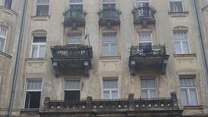 A multi-story building with balconies, a plaque, and a sign indicating the address. - Hostel Lwowska 11 (Warsaw)