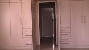 Ein Zimmer mit Kleiderschrank und einer Tür zu einem weiteren Raum.