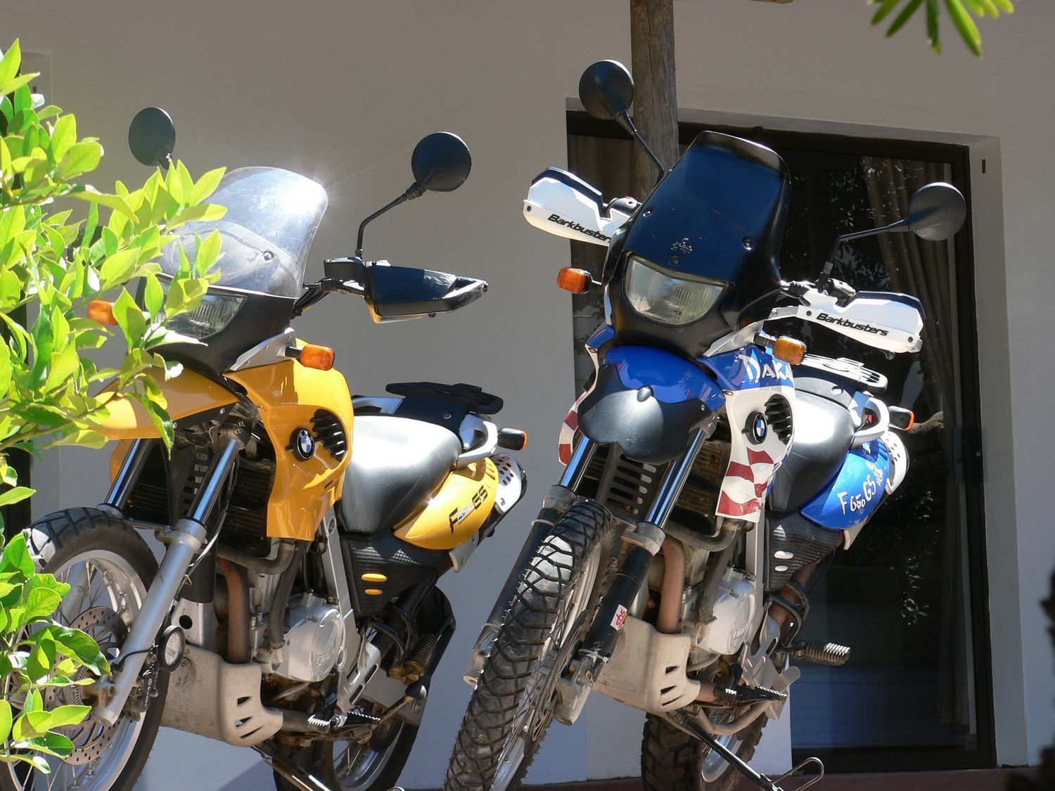 Deux motos sont garées devant un immeuble.