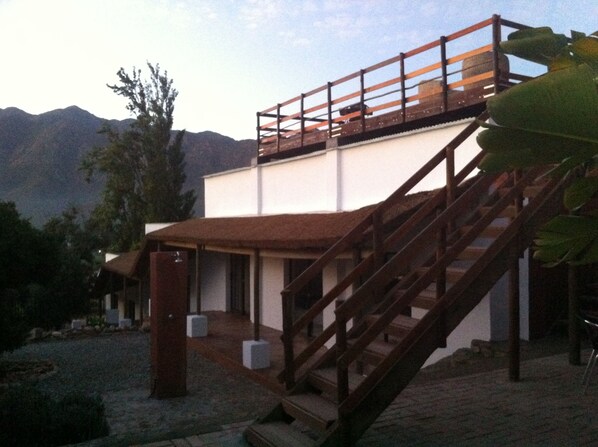 Un edificio de dos pisos con una escalera de madera que lleva a un balcón.