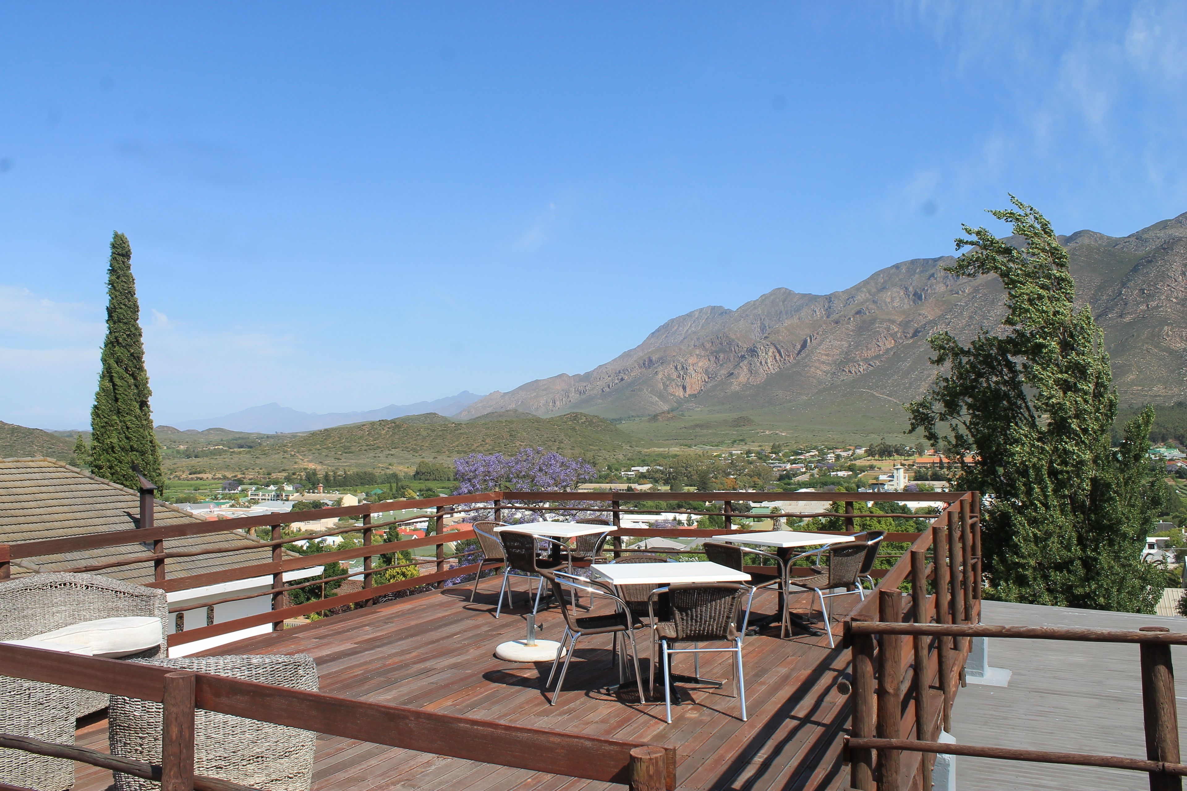 A wooden deck with outdoor seating and a mountain view.